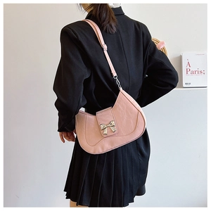 Pink crescent crossbody bag featuring a silver bow buckle and adjustable shoulder strap