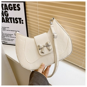 Detail view of the cream pleated leather shoulder bag with a silver bow buckle