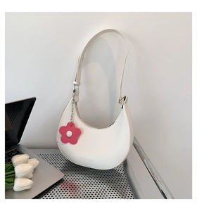 Dettaglio della borsa hobo bianca con ciondolo a fiore rosa e logo su base in metallo