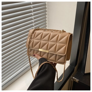 Dettaglio borsa a tracolla trapuntata color cammello con cuciture geometriche e fibbia oro