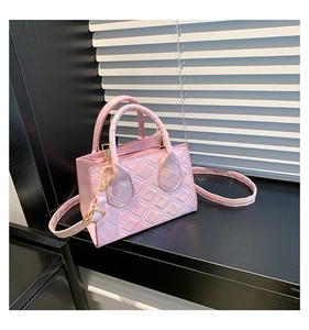 Detailed macro view of pink quilted texture on a mini bag with gold metal hardware