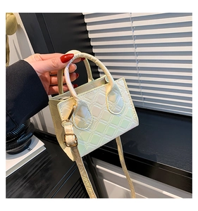 Detail of pearlescent light green quilted mini handbag with gold hardware and top handle