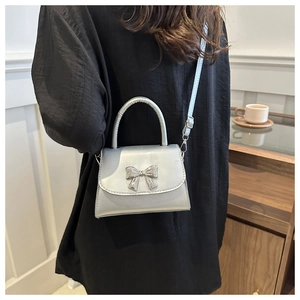 Silver bow crossbody bag with metallic mirror finish and adjustable shoulder strap
