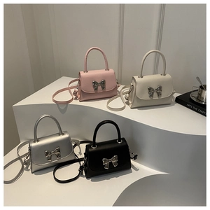 Mini crossbody bags collection featuring bow clasps on minimalist white pedestals