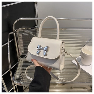 Detail of white PU leather mini handbag with silver metal bow and sturdy handle