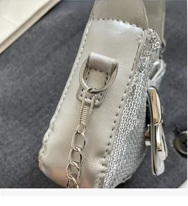 Détail du sac à paillettes argenté montrant l'anneau en D et la bandoulière en chaîne