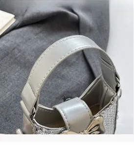 Vue macro des paillettes argentées et de la poignée en cuir du sac avec nœud déco