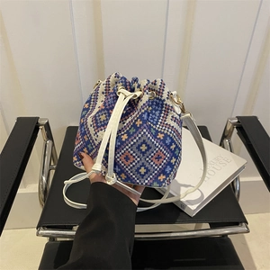 Bohemian woven bucket bag with geometric patterns, drawstring closure and leather strap