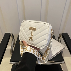 Sac bandoulière matelassé crème avec breloque cerf doré et large sangle à motifs