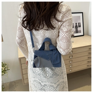 Détail du sac à main en denim patchwork avec poignée nouée et bandoulière sur un modèle