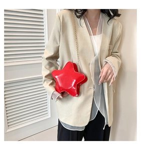 Detail of red pentagram star crossbody bag in glossy patent leather with gold chain