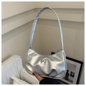 Détail du sac hobo argenté plissé avec finition métallique et ornement papillon en relief