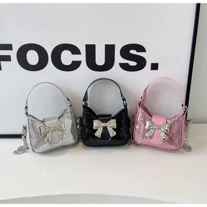 Détail de mini sacs à main à paillettes en argent, noir et rose avec nœud papillon