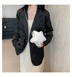 Modern white star-shaped crossbody chain bag styled with black blazer and white skirt