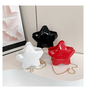 Detailed view of three shiny patent leather star-shaped bags in white, black, and red colors