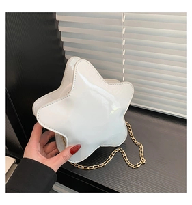 Détail du sac blanc en cuir verni en forme d'étoile avec bandoulière chaîne dorée à la main