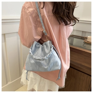 Light blue drawstring bucket bag with pleated cloud texture and woven handle detail