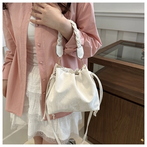 White pleated bucket bag detail with thick woven handle and drawstring closure