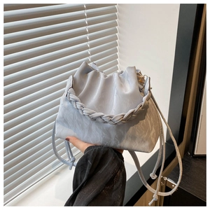 Close-up of pleated light blue handbag with marble texture and woven top handle detail