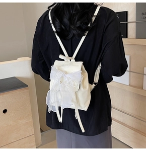 Détail d'un mini sac à dos crème orné d'un grand nœud en organza blanc au dos