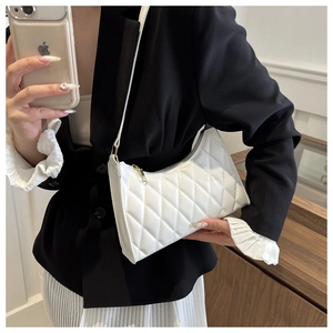 Détail de la broderie matelassée blanche sur le sac à bandoulière en forme de croissant