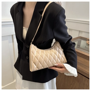 Gros plan détaillé de la couture matelassée sur le sac à bandoulière minimaliste crème