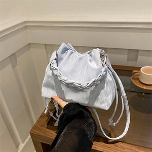 Minimalist light blue bucket bag with woven handle and pleated texture for women