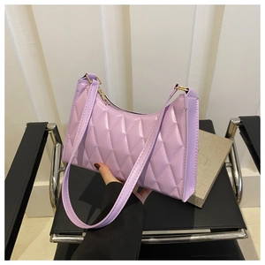 Détail d'un sac baguette lilas avec surpiqûres matelassées classiques sur une chaise