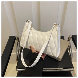 Détail de la broderie à losanges matelassée blanche sur le sac sous l'aisselle en cuir