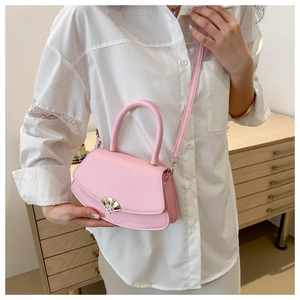 Détail du sac à main rose montrant la boucle en métal doré et la petite poignée