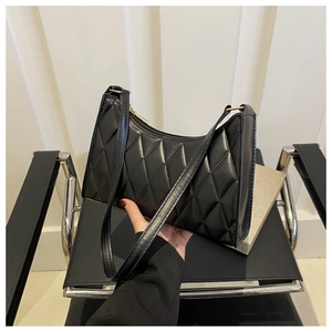 Détail du sac bandoulière matelassé noir avec motif losange et zip doré brillant