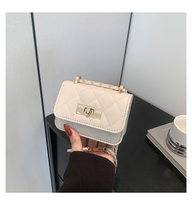 Dettaglio mini borsa bianca trapuntata con chiusura dorata e tracolla a catena