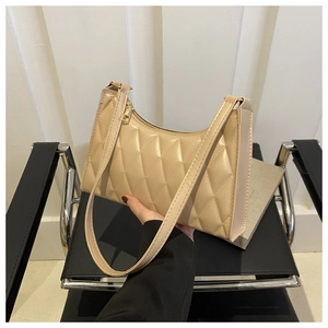 Détails de la texture matelassée beige et du zip doré sur le sac sous le bras élégant