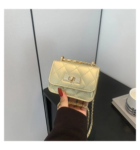 Dettaglio della mini borsa trapuntata oro chiaro con chiusura a scatto e catena in pelle
