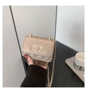 Dettaglio mini borsa trapuntata beige con catena dorata e chiusura a girello quadrata