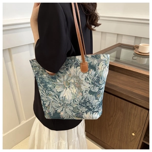 Close-up of vintage floral tapestry fabric and leather handle on shoulder tote bag
