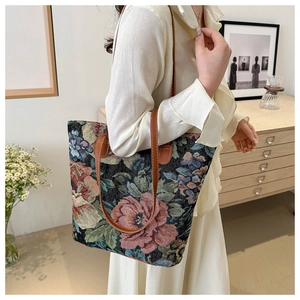 Close-up of vintage jacquard tote bag with red rose pattern and brown leather straps