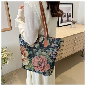 Detail of vintage floral jacquard tote bag with leather straps on a female model