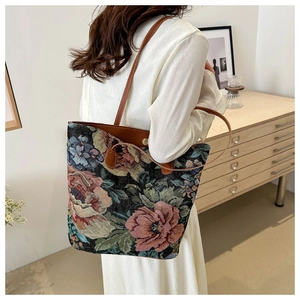 Close-up of floral tapestry fabric and brown leather handle on a large tote bag