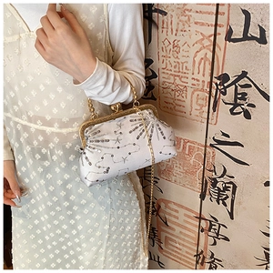 Detailed view of vintage sequined beadwork and gold chain strap on the white clutch bag