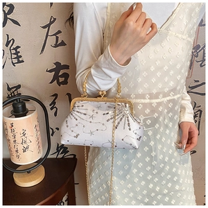 Detailed side view of a white sequin evening clutch bag with gold chain and vintage clasp