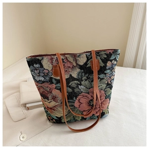 Close-up of vintage floral jacquard tote bag with rose patterns and brown leather straps