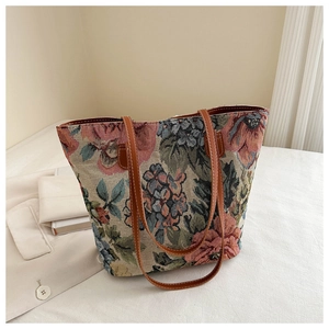 Detailed view of floral tapestry tote with premium brown leather straps and vintage fabric