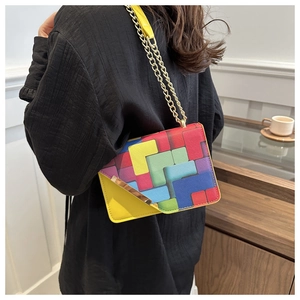 Fashionable crossbody bag featuring vibrant color-block geometric patterns and gold chain strap