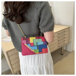 Chic geometric block crossbody bag with gold chain strap shown on model in a cozy room
