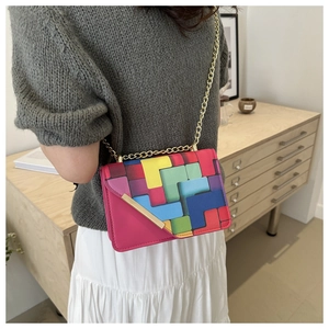 Detail of color-block geometric crossbody bag with gold chain strap on model