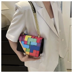 Detail of colorful geometric pattern crossbody bag with golden chain strap on model