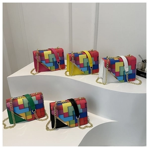 Five colorful geometric pattern crossbody bags with gold chains on display stands
