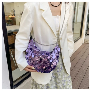 Detail of sequined purple crescent bag with silver chain strap on a white blazer