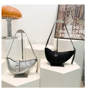 Détail de sacs demi-lune en noir et argent avec bandoulières chaînes et boucles en métal